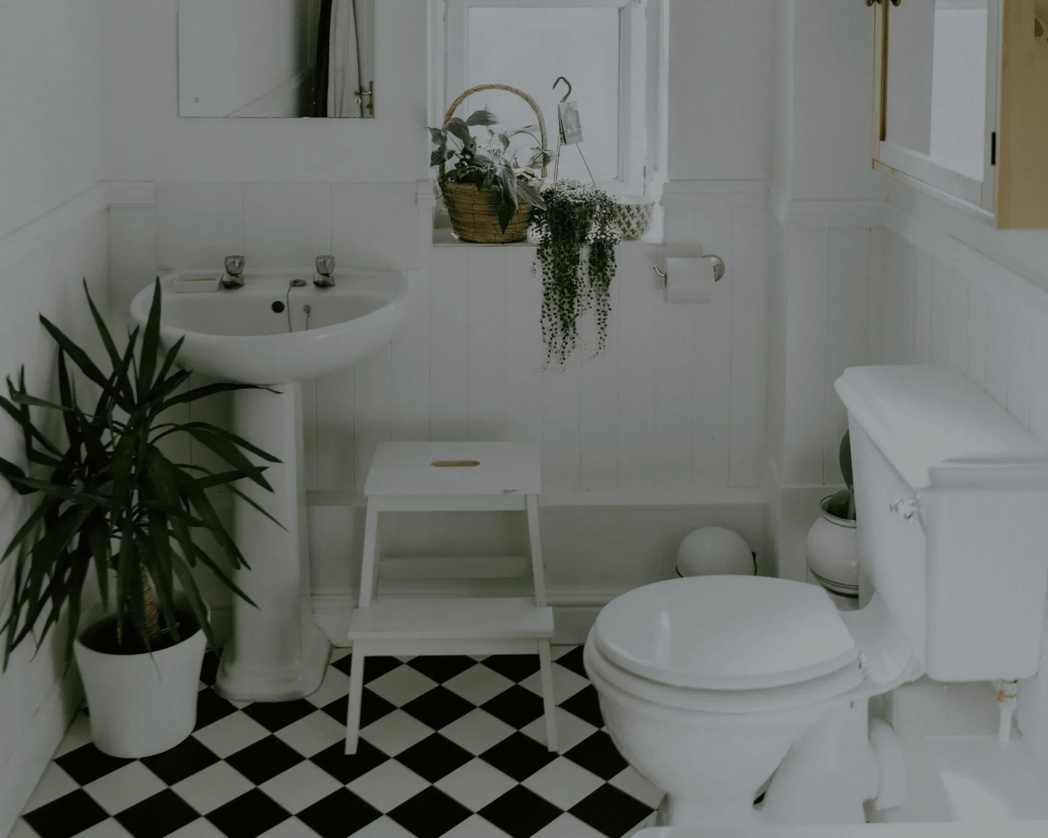 Bathroom with checkered tile floor, pedestal sink, and toilet