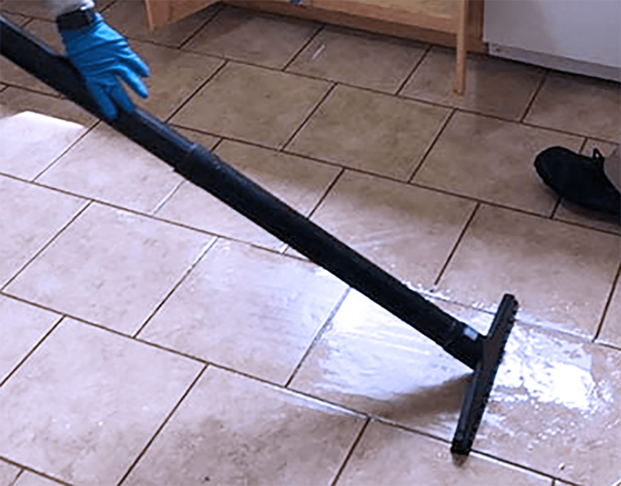 A person using a vacuum to clean the floor.