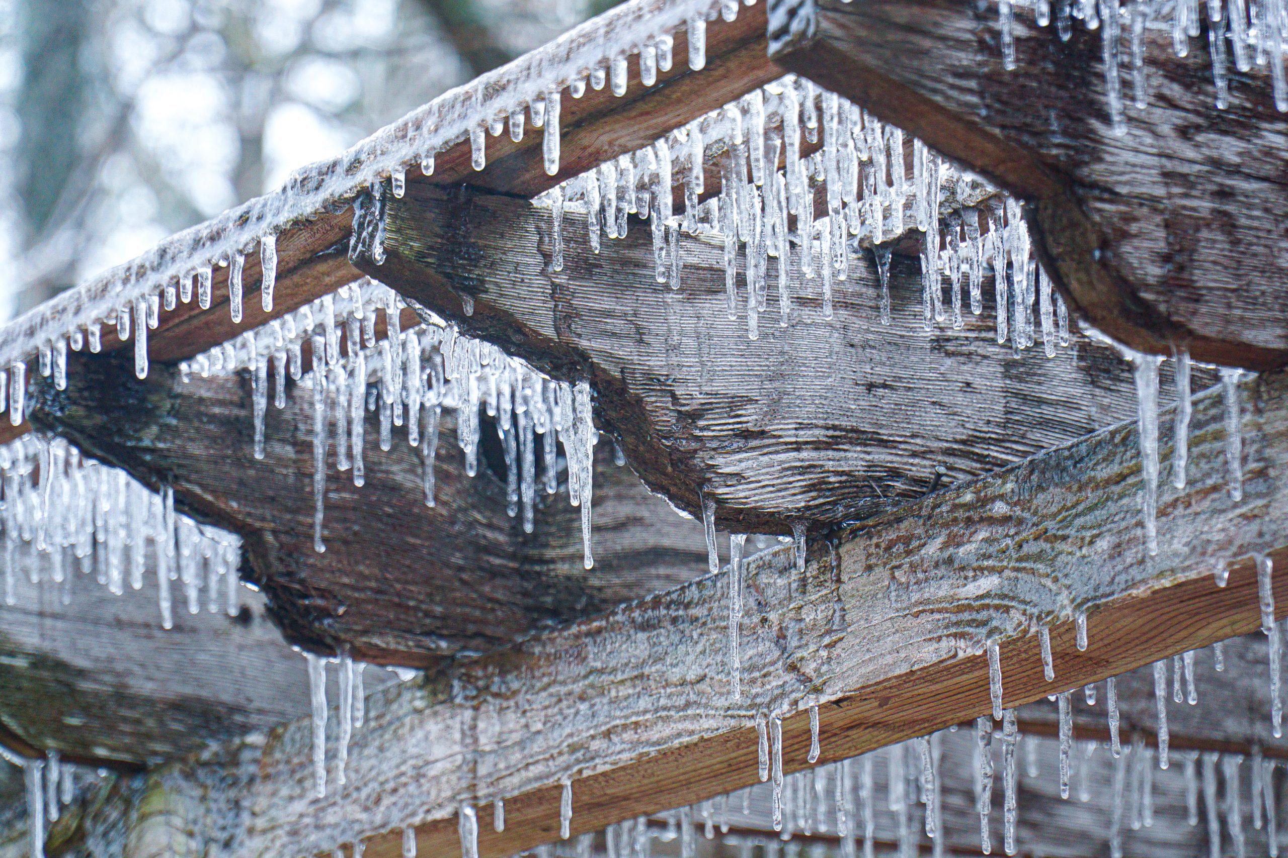 A close up of icicles hanging from the roof