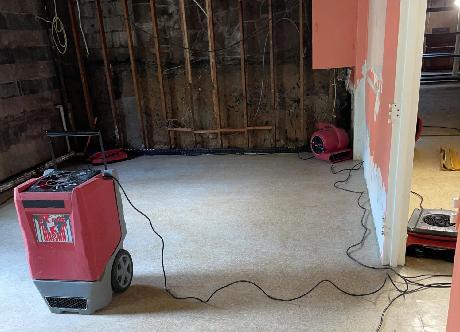 A room with the walls being remodeled and a red machine