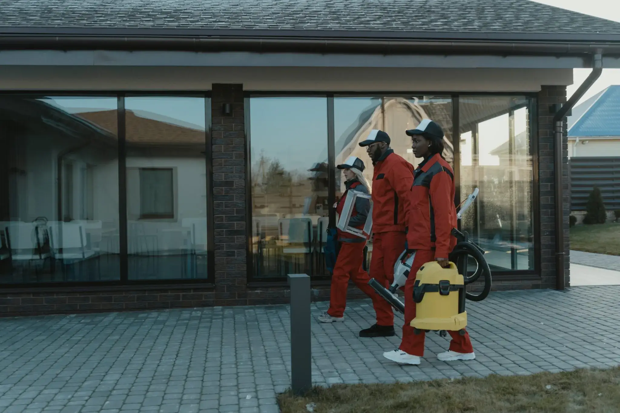 Two people in red suits walking down a street.